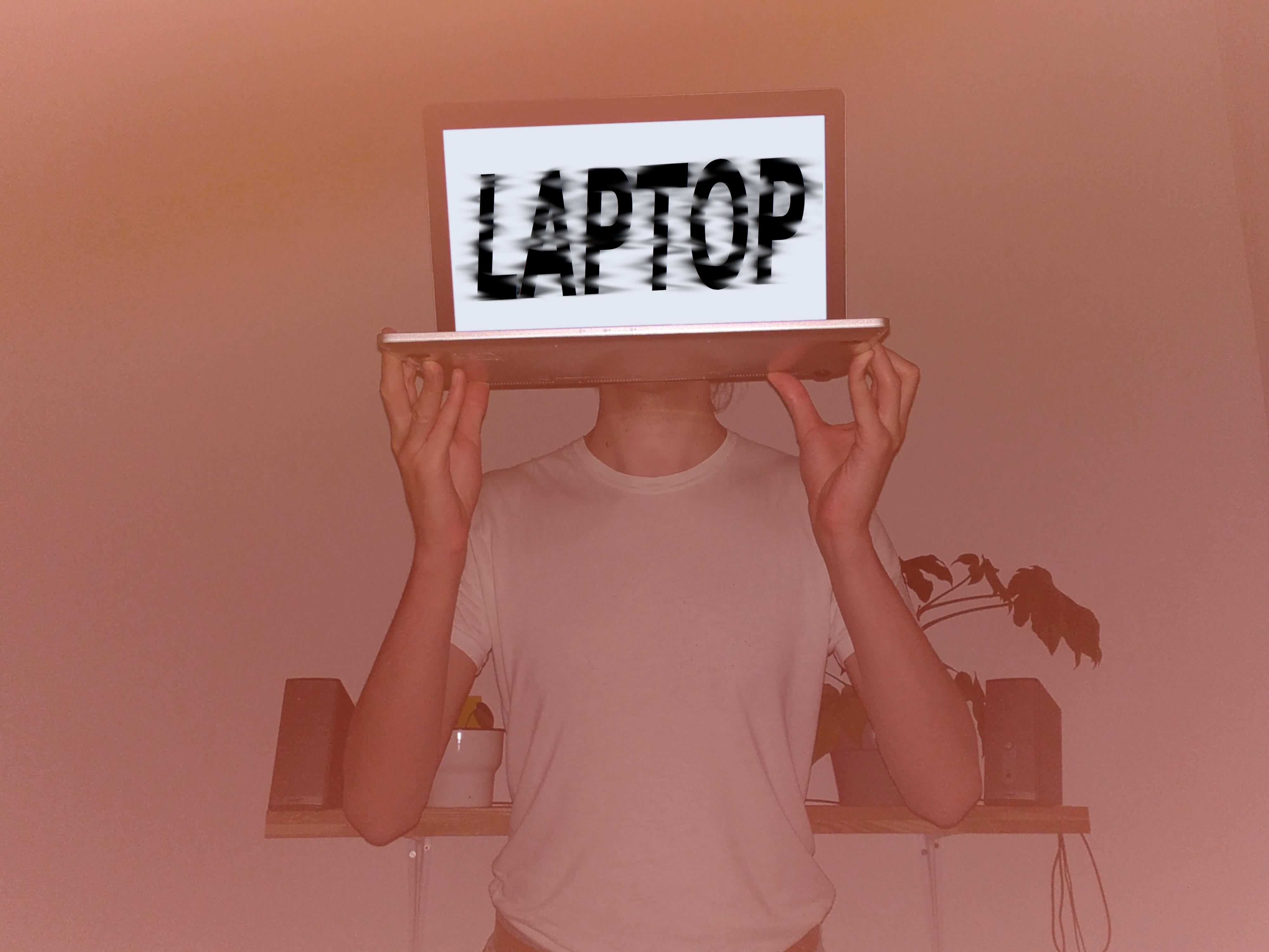 Foto von Simon Bahr, der sich einen Laptop vor seinen Kopf hält.